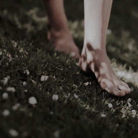 A person walks barefoot on lush green grass, enjoying the sensation of nature beneath their feet.